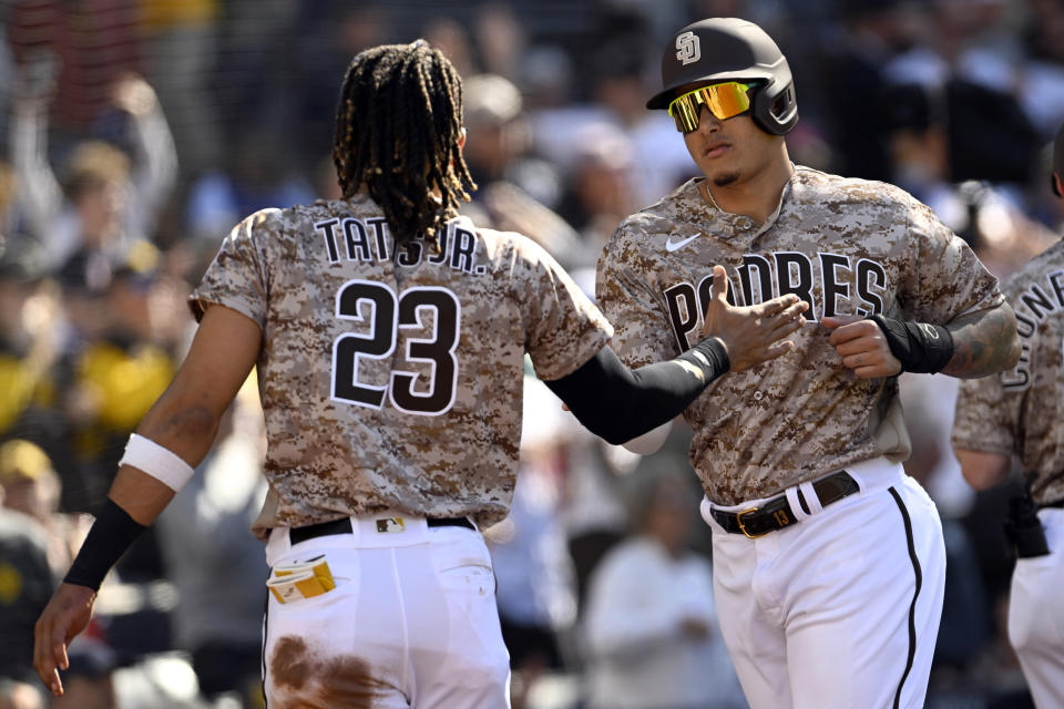 San Diego Padres' Fernando Tatis Jr., left, celebrates with Manny Machado after Machado scored on an RBI-double by Xander Bogaerts against the Los Angeles Dodgers during the first inning of a baseball game in San Diego, Sunday, May 7, 2023. (AP Photo/Alex Gallardo)