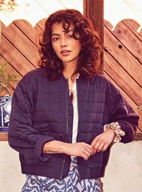 Model wearing a cropped bomber jacket in marine blue