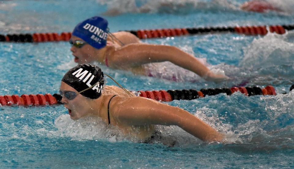 Kiera Luhrs of Milan hangs on to beat Joslyn Ball of Dundee in the 100 yard butterfly in the Monroe County Swim Finals Saturday.