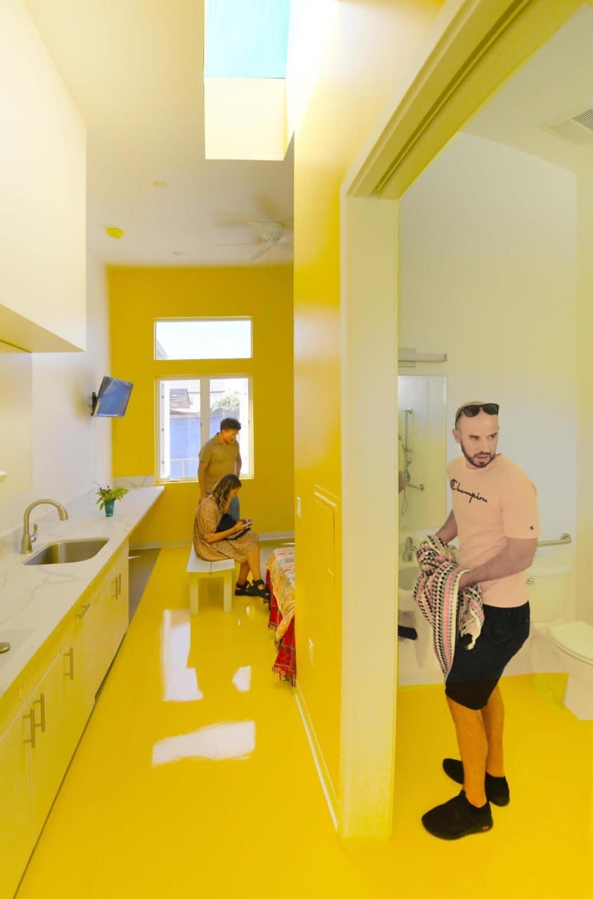 Long galley-style kitchen in a bright yellow Willowbrook apartment.