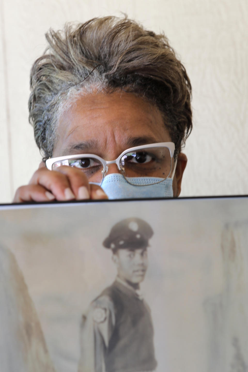 In this Monday, May 18, 2020 photo, Belvin Jefferson White poses with a portrait of her father Saymon Jefferson at Saymon's home in Baton Rouge, La. Belvin recently lost both her father and her uncle, Willie Lee Jefferson, to COVID-19. (AP Photo/Gerald Herbert)