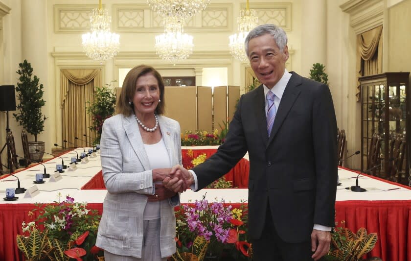 In this photo provided by Ministry of Communications and Information, Singapore, U.S. House Speaker Nancy Pelosi, left, and Prime Minister Lee Hsien Loong shake hands at the Istana Presidential Palace in Singapore, Monday, Aug. 1, 2022. Pelosi arrived in Singapore early Monday, kicking off her Asian tour as questions swirled over a possible stop in Taiwan that has fueled tension with Beijing. (Ministry of Communications and Information, Singapore via AP)