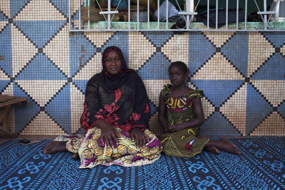 Oumou Ndiaye and her daughter Aissata Golfa pose for a picture in their house in Bamako, Mali