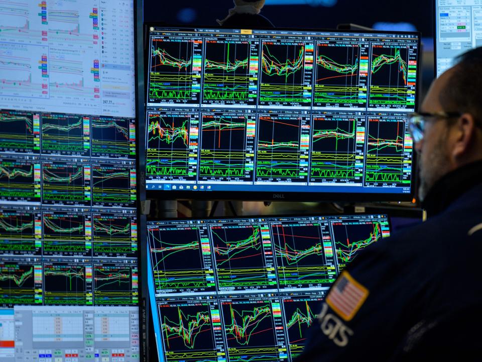 A trader looks at market charts on the floor of the New York Stock Exchange.