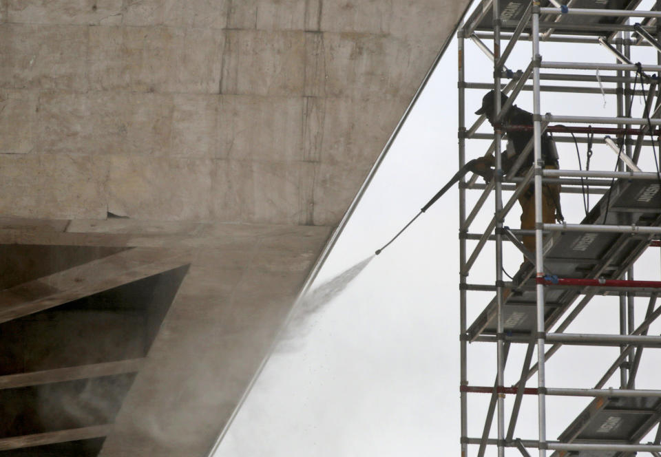 A worker sprays water to clean the National Monument in Jakarta, Indonesia, Friday, May 9, 2014. The 132-meter (433-feet) tall monument, a popular landmark in the capital, is being cleaned for the first time in more than two decades. (AP Photo/Dita Alangkara)