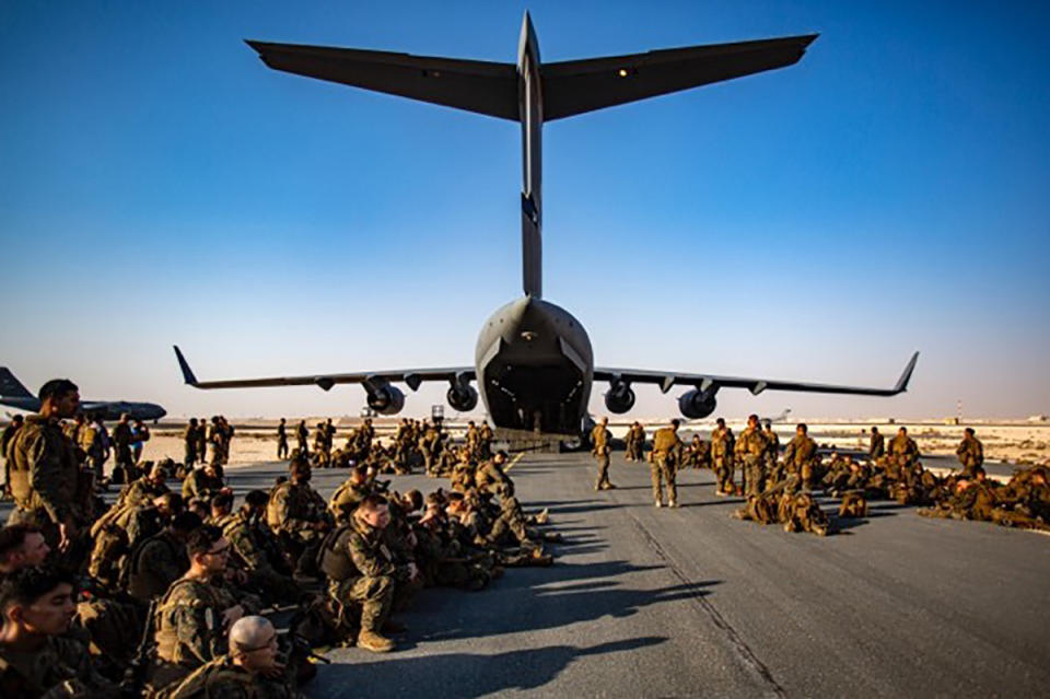 Marines assigned to the 24th Marine Expeditionary Unit (MEU) await a flight to Kabul Afghanistan, at Al Udeied Air Base, Qatar Tuesday, Aug. 17, 2021. Marines are assisting the Department of State with a drawdown of designated personnel in Afghanistan. (1st Lt. Mark Andries/U.S. Marine Corps via AP)