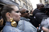 Kanye West, centre, attends the Kenzo fall-winter 22/23 men's collection, in Paris, Sunday, Jan. 23, 2022. (AP Photo/Lewis Joly)