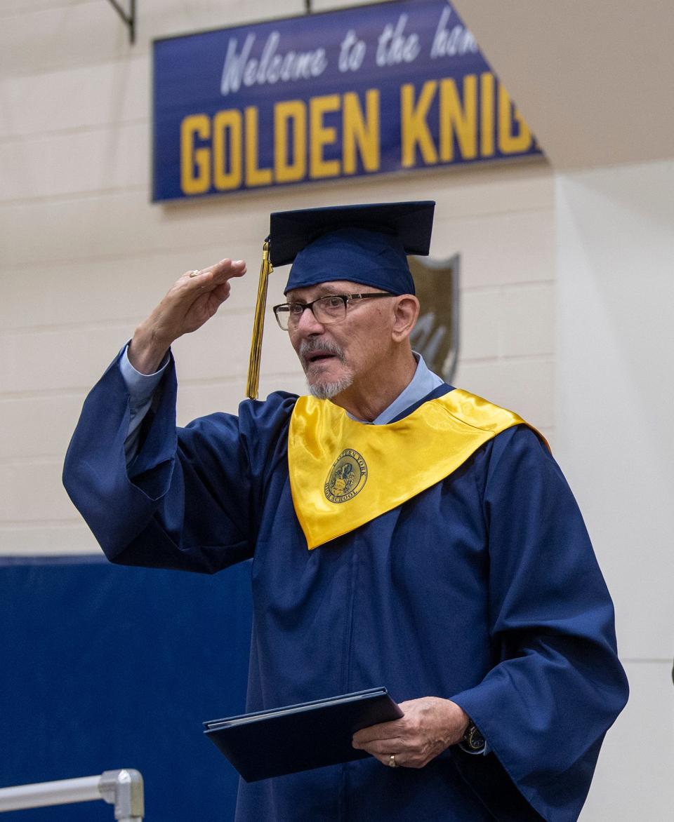 Jon Langione salutes his fellow class of 2022 after receiving his diploma Wednesday.
