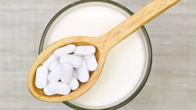 calcium tablets above milk glass