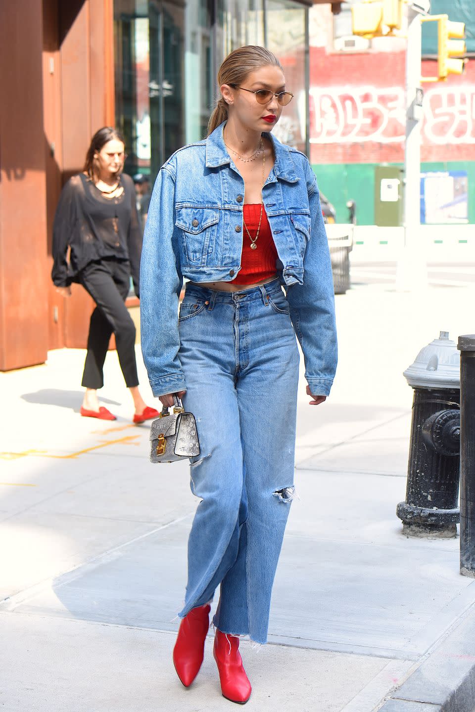 <p>As a dedicated lipstick-wearer, Gigi basically matched her entire outfit to her fave lippie: bright red. She rocked red shoes, a red crop, and red lipstick with denim staples to tie it all together. </p>