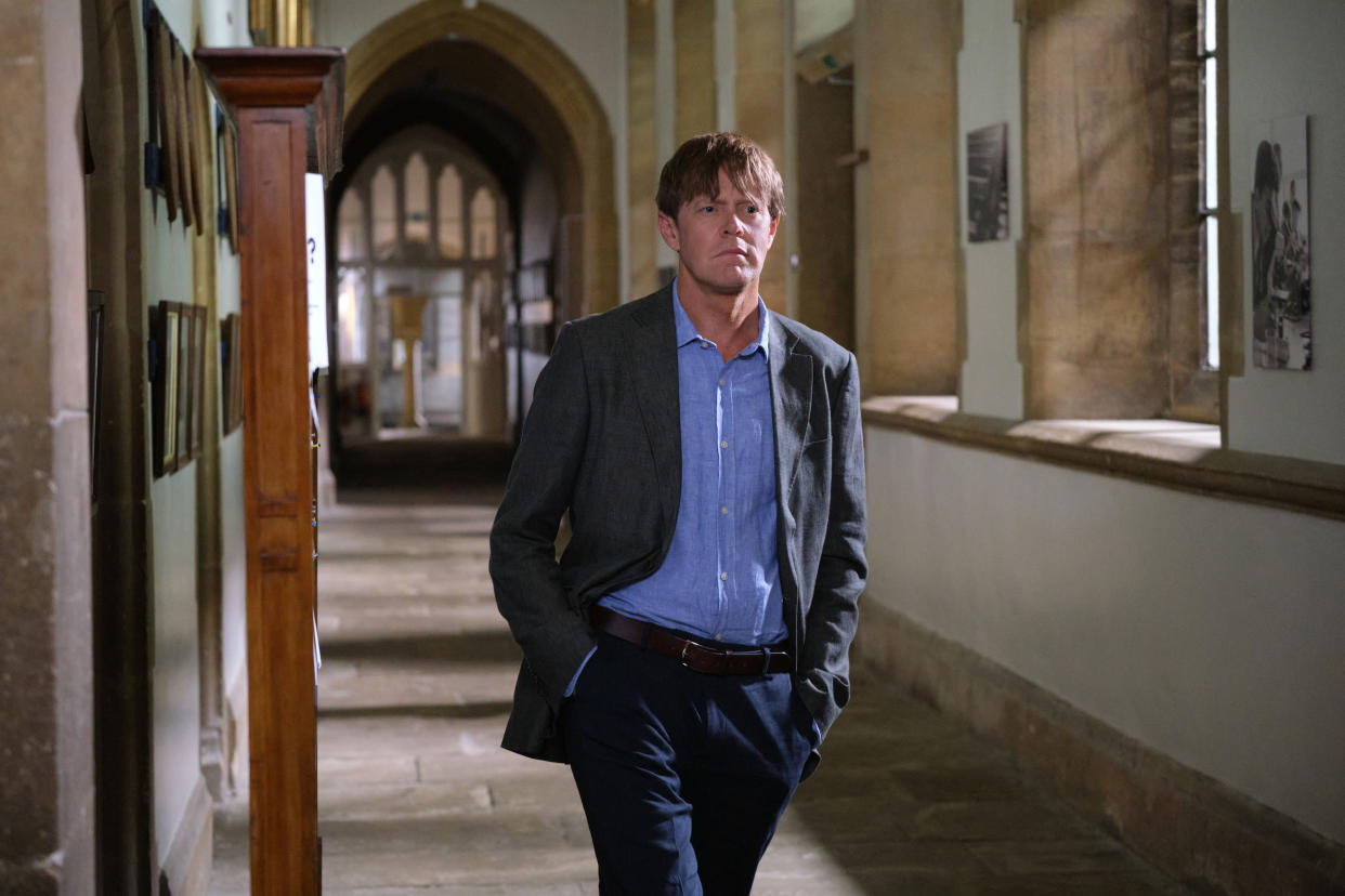  Beyond Paradise season 2 episode 4: DI Humphrey Goodman (Kris Marshall) walks down the whitewashed stone corridor of an elite boarding school with his hands in his pockets. 