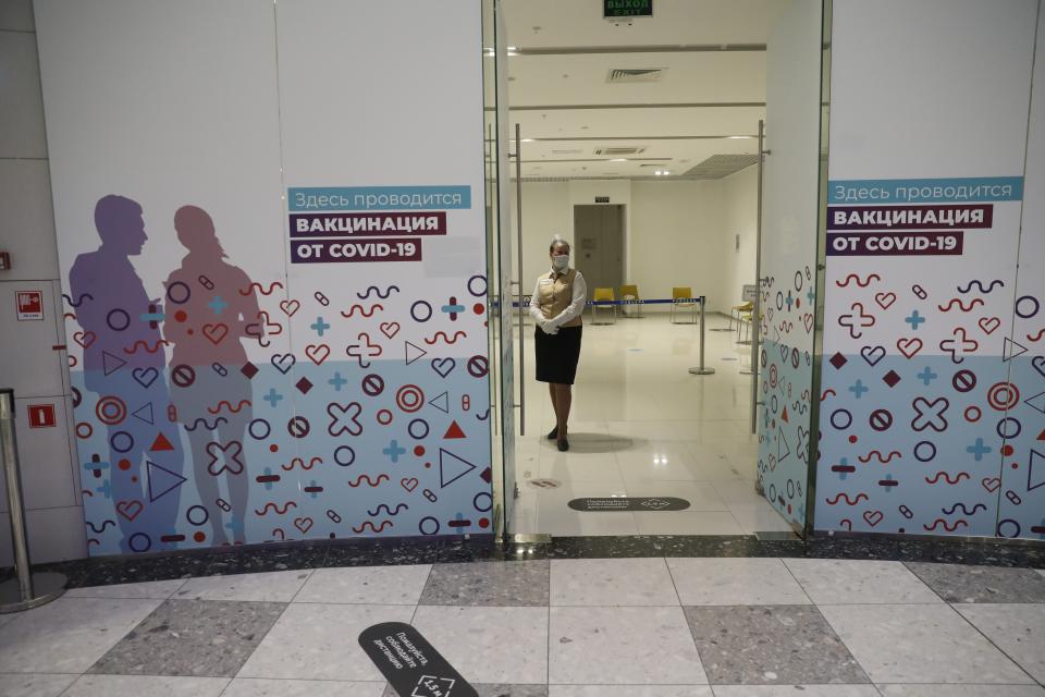 An employee stand waiting for customers at a vaccination point in Moscow, Russia, Wednesday, April 7, 2021. The low vaccine uptake hinges on several factors. Russian drug makers have been slow to ramp up mass production of the vaccine, leading to shortages in many regions last month. As more shots became available, people's unwillingness to get them emerged as another apparent problem. So far only 27.9 million two-dose sets have been produced, and only 15 million have been released into circulation after undergoing quality control. (AP Photo/Pavel Golovkin)