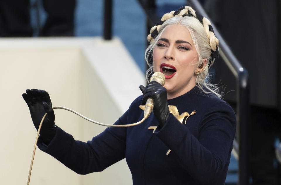 ARCHIVO – En esta fotografía del 20 de enero de 2021 Lady Gaga canta el himno nacional durante la ceremonia inaugural del presidente Joe Biden en el Capitolio Federal en Washington. Fiscales señalan que tres hombres condujeron cerca de una zona de Hollywood a finales de febrero, buscando perros caros para robar. Su noche terminó con el robo violento de los perros bulldog francés de Lady Gaga. (Foto AP/Saul Loeb, Pool, archivos)