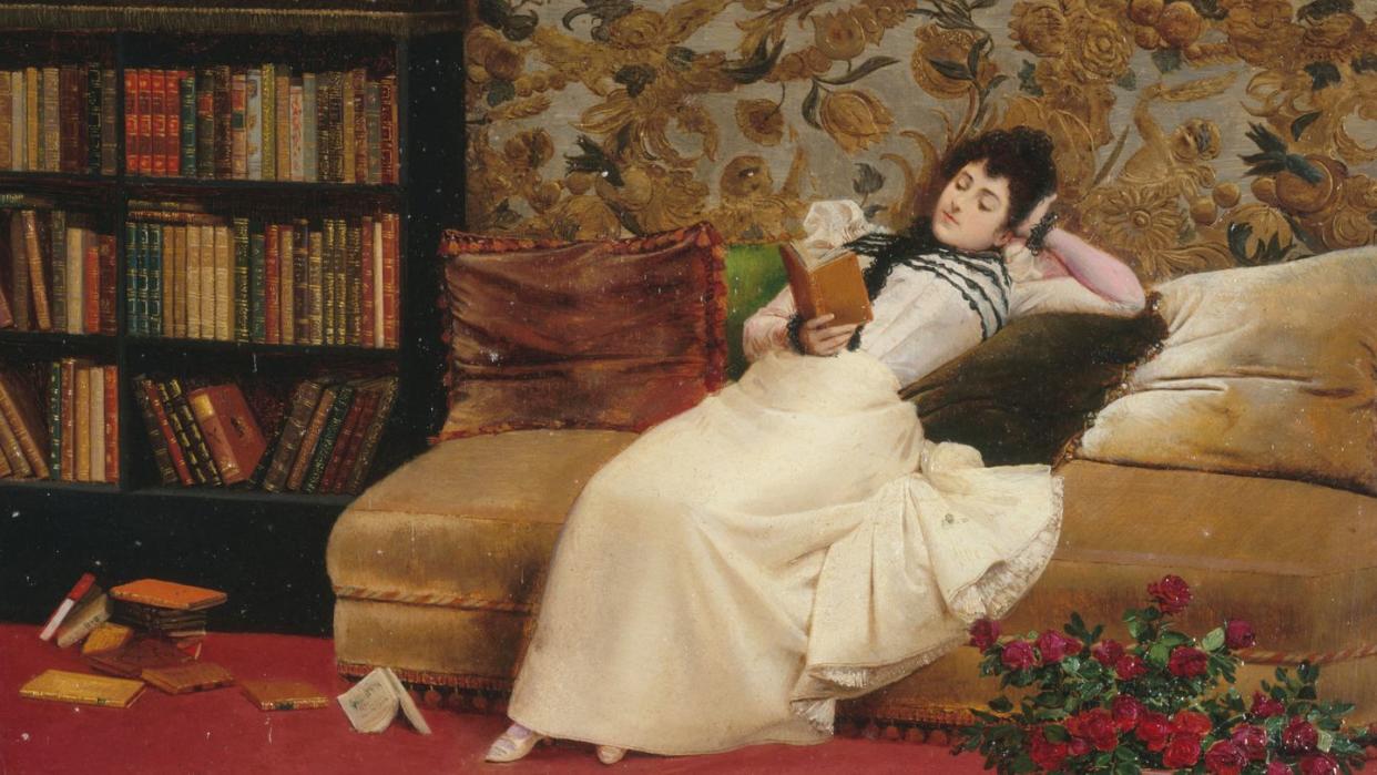 woman reading a book on the couch