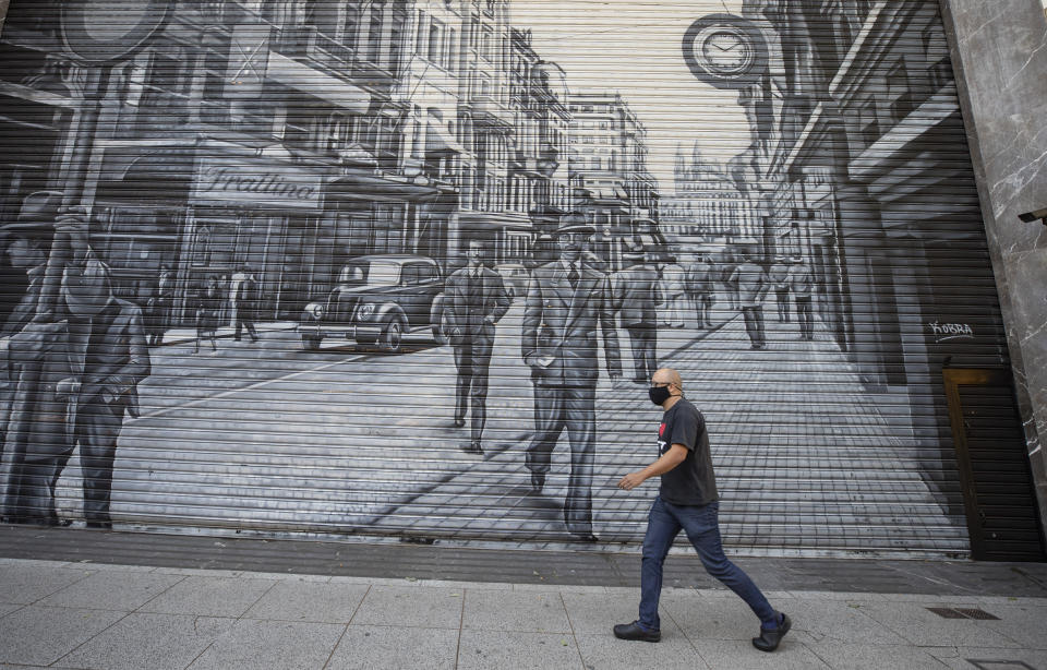 A man walks in front of a shuttered outfit store during a quarantine imposed by the state government to help contain the spread of the new coronavirus in Sao Paulo, Brazil, Monday, June 1, 2020. (AP Photo/Andre Penner)