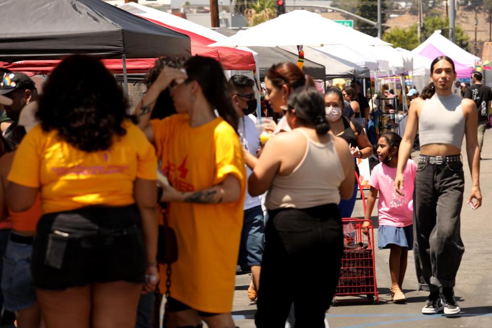 DeMarkus Trinidad-Williams, right, walks through the Queer Mercado.