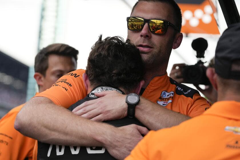 Pato O'Ward, of Mexico, front center, is comforted by a crew member after finishing second in the Indianapolis 500 auto race at Indianapolis Motor Speedway, Sunday, May 26, 2024, in Indianapolis. (AP Photo/Darron Cummings)