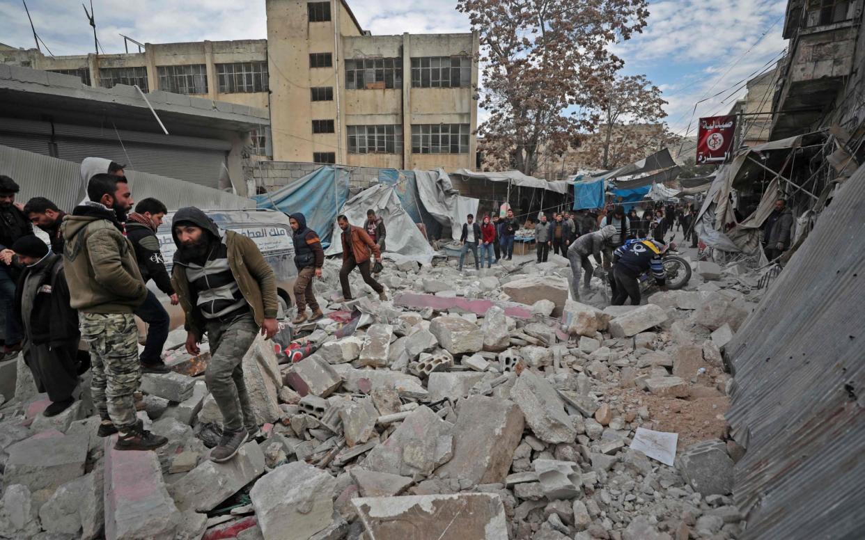 Syrians gather at the site of an airstrike in Idlib earlier this week - AFP