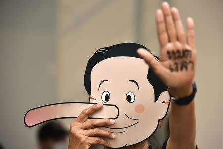 A Pro-democracy activist holds up a mask to mock Thailand's Prime Minister Prayuth Chan-ocha as Pinocchio during a protest against junta at a university in Bangkok, Thailand, February 24, 2018. REUTERS/Panumas Sanguanwong
