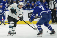 San Jose Sharks forward Logan Couture (39) shoots the puck between the legs of Toronto Maple Leafs defenseman Justin Holl (3) during the first period of an NHL hockey game Friday, Oct. 22, 2021, in Toronto. (Evan Buhler/The Canadian Press via AP)