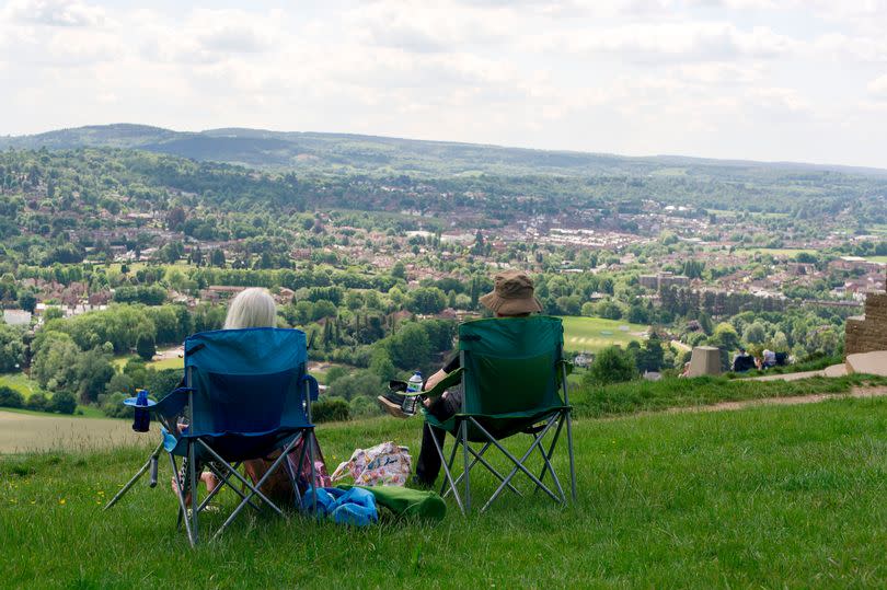 A couple enjoy the sunny weather and the view of Dorking from Box Hill