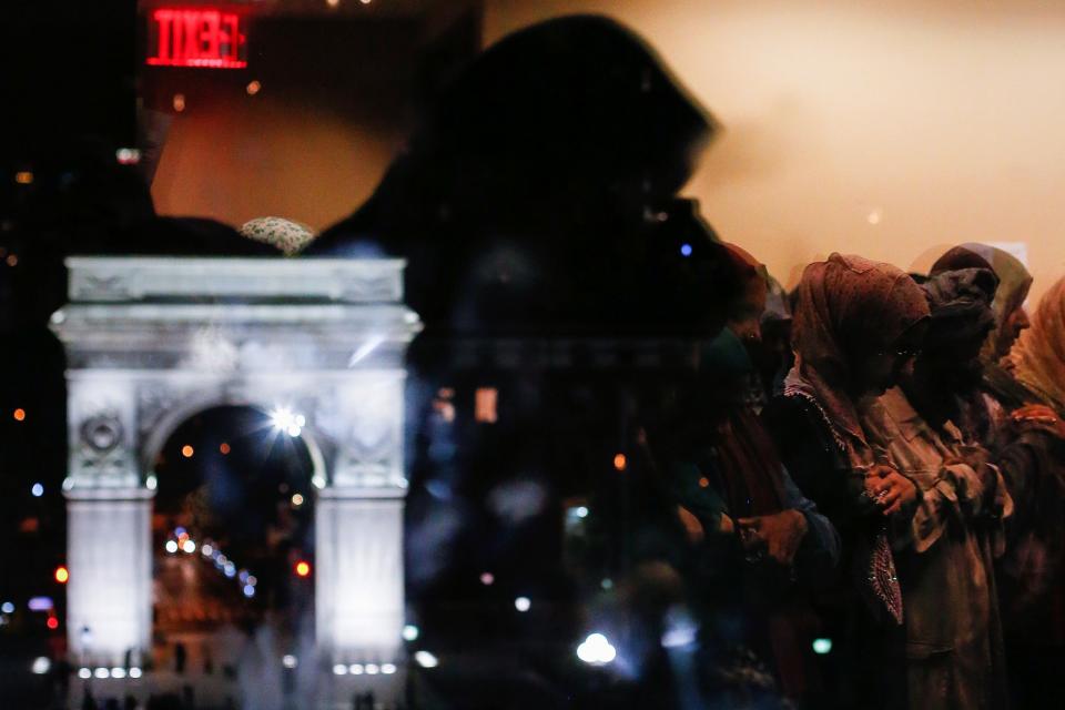 <p>Washington Square Arch is seen on the left as Muslim women praying Tarawih prayers are reflected in the window of the Islamic Center at New York University ahead of Ramadan in Manhattan, New York, May 26, 2017. (Gabriela Bhaskar/Reuters) </p>