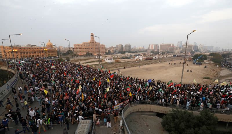 Pakistani Shi'ite Muslims carry flags and signs to protest the death of Iranian military commander Qassem Soleimani, who was killed in a airstrike near Baghdad, as they march on a road leading towards the U.S. consulate in Karachi