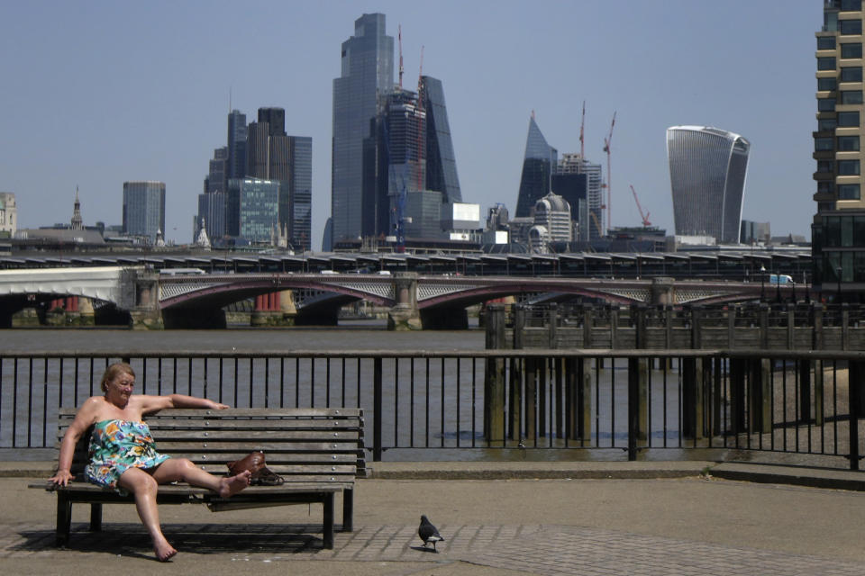 Una mujer soleándose cerca del río Támesis en Londres el 17 de junio de 2022. (Foto AP /Kirsty Wigglesworth)