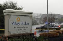 A police car blocks the scene of a shooting at Village Shalom, an assisted living center, as rain falls in Overland Park, Kansas April 13, 2014. (REUTERS/Dave Kaup)