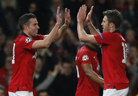 Manchester United's Robin van Persie (L) celebrates with teammate Michael Carrick a second goal against Olympiakos during their Champions League soccer match at Old Trafford in Manchester, northern England, March 19, 2014. REUTERS/Phil Noble
