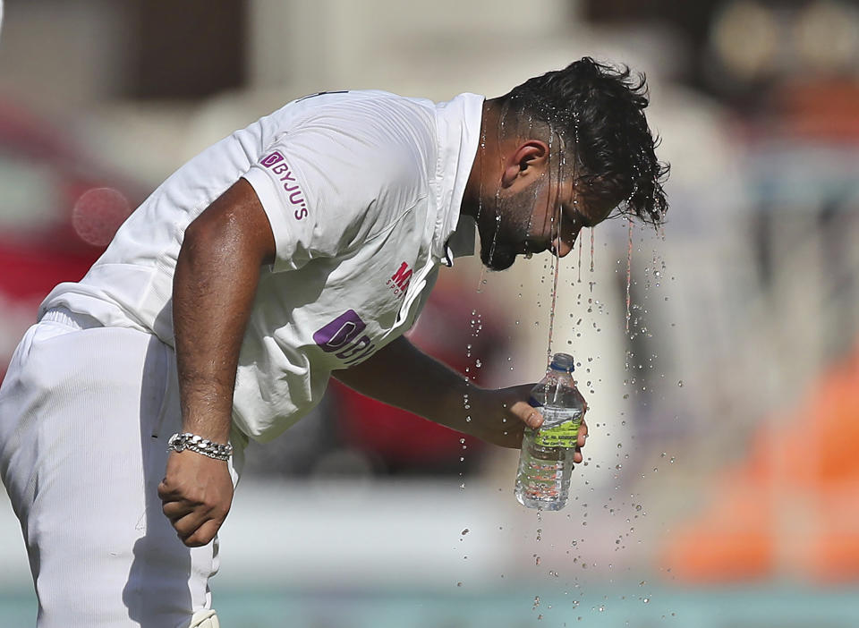 India's Rishabh Pant pours cold water on his head to beat the heat drinks water during the second day of fourth cricket test match between India and England at Narendra Modi Stadium in Ahmedabad, India, Friday, March 5, 2021. (AP Photo/Aijaz Rahi)