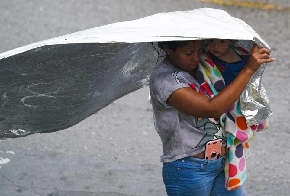 Una migrante venezolana usa una manta de emergencia para cubrirse de la lluvia, cerca de las orillas del Río Grande en Matamoros, México, el sábado 13 de mayo de 2023.