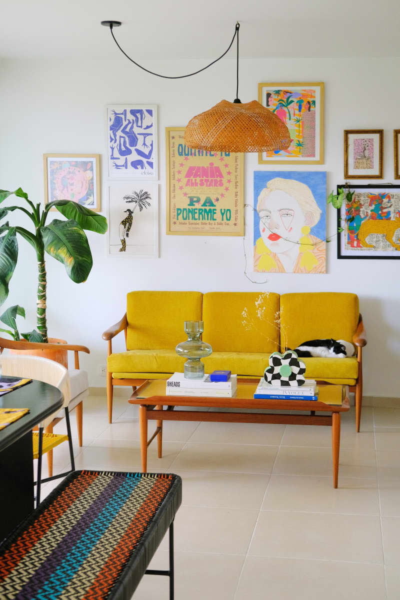 A white-walled living room full of colorful furniture and artwork.