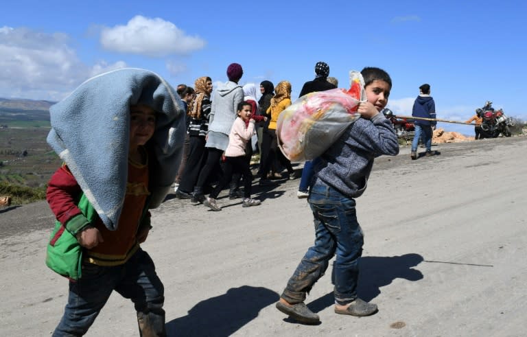 Civilians flee a Turkish offensive around the city of Afrin in northern Syria along a mountain road in the government-controlled part of the northern Aleppo province, on March 16, 2018