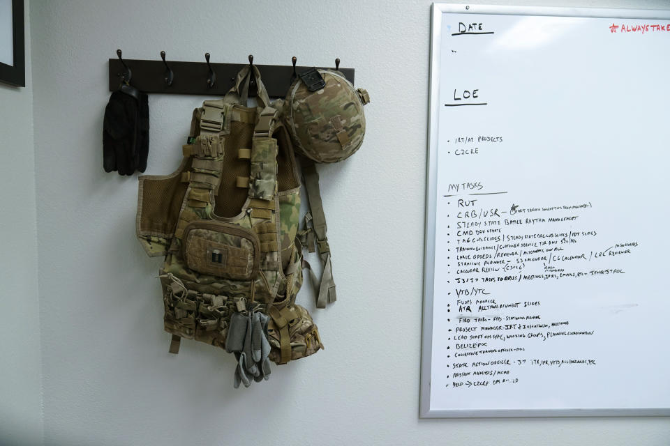 Tactical gear and a whiteboard hang over the cot where Capt. Michael Switzer sleeps in his office at Camp Beauregard in Pineville, La., Friday, July 30, 2021. (AP Photo/Gerald Herbert)