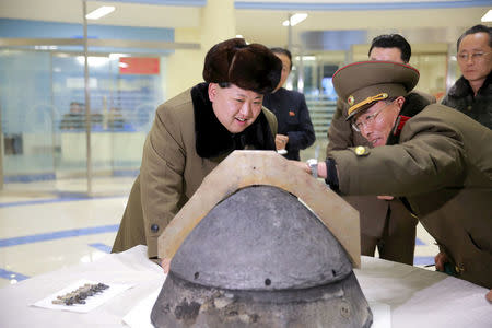 FILE PHOTO: North Korean leader Kim Jong Un looks at a rocket warhead tip after a simulated test of atmospheric re-entry of a ballistic missile, at an unidentified location in this undated file photo released by North Korea's Korean Central News Agency (KCNA) in Pyongyang on March 15, 2016. KCNA/via Reuters/File Photo