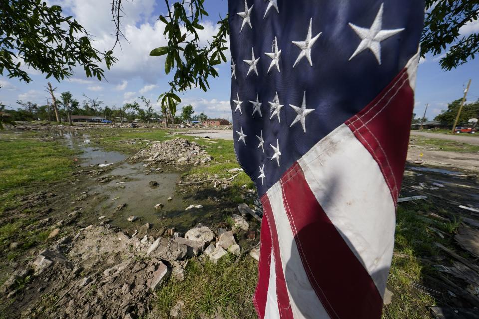 An American flag hangs near rubble of destroyed homes from the deadly tornado in Rolling Fork, Miss., Friday, May 19, 2023. While the dangers of tornadoes to mobile homes have long been known, and there are ways to mitigate the risk, the percentage of total tornado deaths that happen in mobile homes has been increasing. (AP Photo/Gerald Herbert)