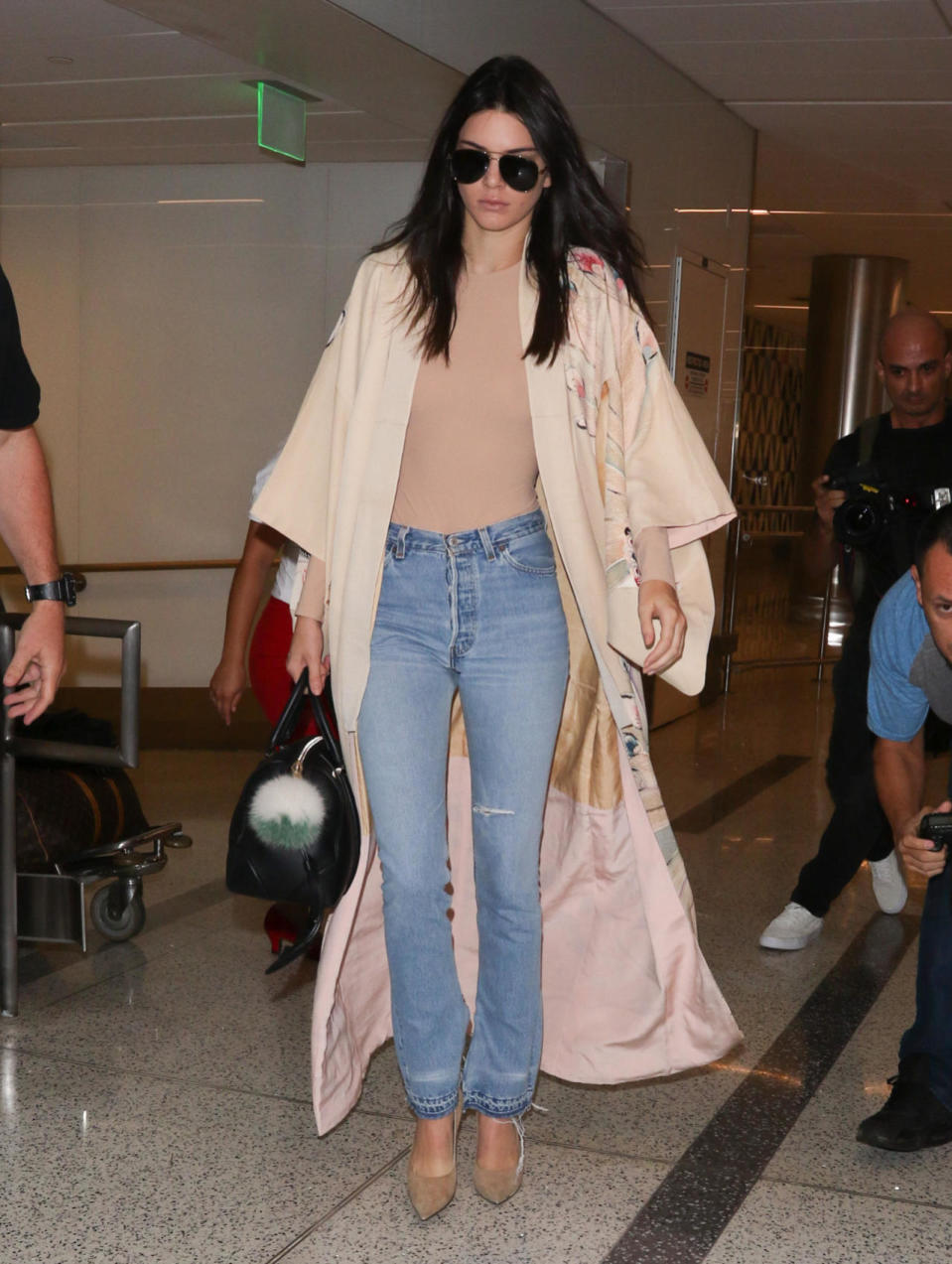Kendall Jenner wears beige bodysuit, jeans, and kimono-style robe at LAX on Oct. 17, 2015 in Los Angeles.