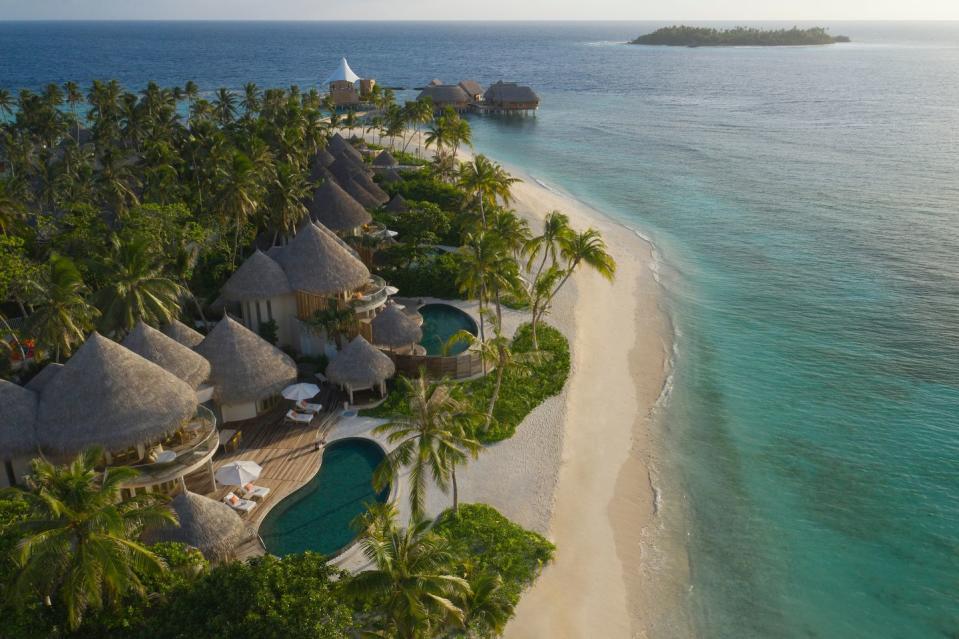 a beach with huts and trees