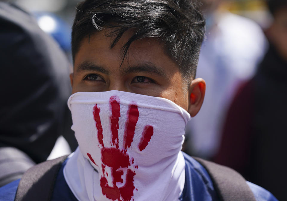 A demonstrator protesting the disappearance of 43 college students takes part in a protest outside of a military base in Mexico City, Friday, Sept. 23, 2022, days before the anniversary of the disappearance of the students in Iguala, Guerrero in 2014. One week prior, Mexican authorities said they arrested a retired general and three other members of the army for alleged connection to their disappearance. (AP Photo/Fernando Llano)