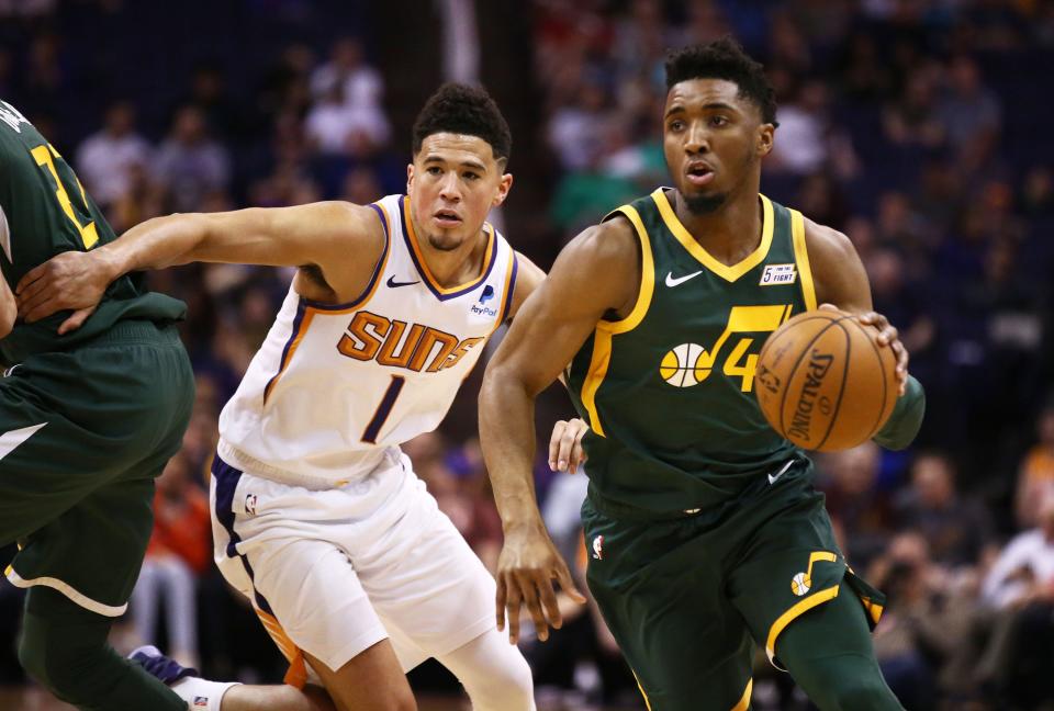 Utah Jazz guard Donovan Mitchell (45) drives past Phoenix Suns guard Devin Booker (1) in the first half on Apr. 3, 2019 at Talking Stick Resort Arena in Phoenix, Ariz.