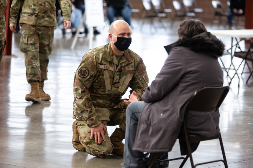 Staff Sgt. Jonathan Ojeda, of the Illinois Air National Guard, chats with a person in the extended observation area after they received their COVID-19 vaccine at the new state-supported mass vaccination site in the Orr Building at the Illinois State Fairgrounds in Springfield, Ill., on Feb. 17.