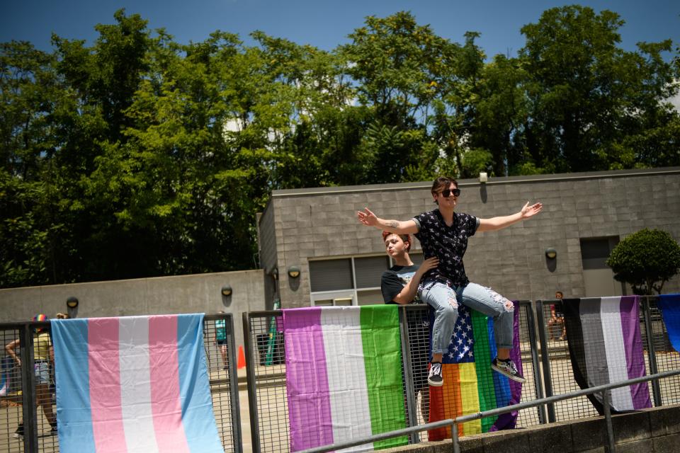 People pose for photos with a variety of Pride flags at the Fayetteville PrideFest on Saturday, June 25, 2022, at Festival Park.