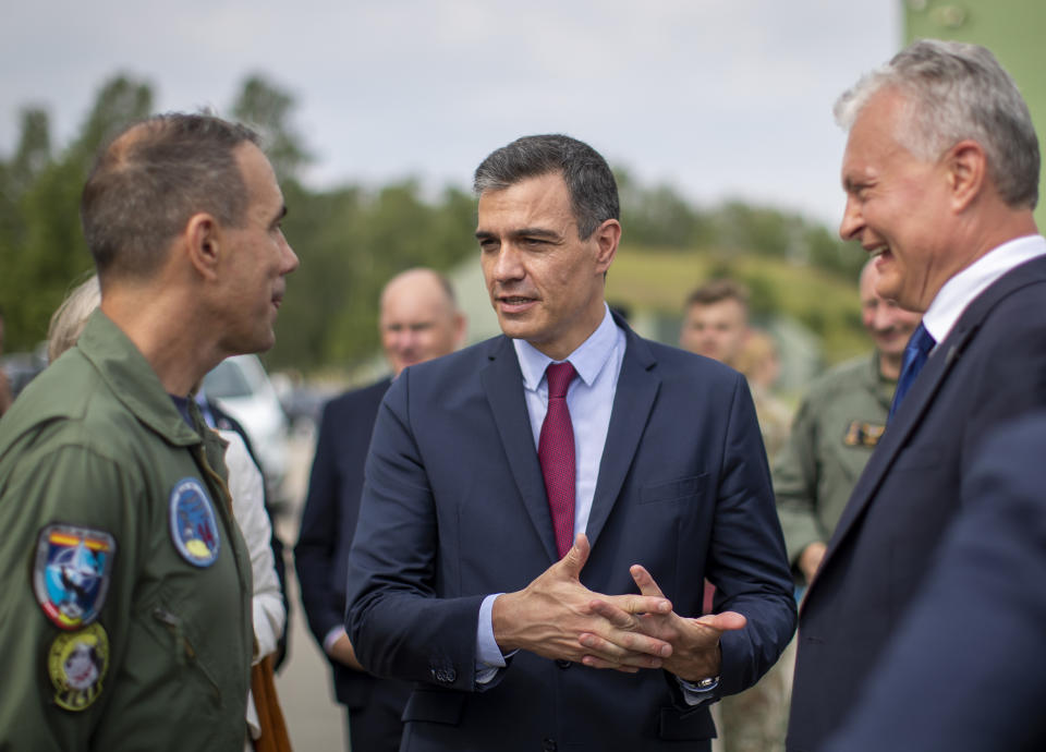 Spain's Prime Minister Pedro Sanchez, center, and Lithuanian President Gitanas Nauseda, right, speaks with Commander of the NATO's Baltic Air Policing Mission Lieutenant Colonel Bayardo Abos Alvares-Buiza, left, during a visit to the military air force base at Siauliai, some 220 kms (136,7 miles) east of the capital Vilnius, Lithuania, Thursday, July 8, 2021. (AP Photo/Mindaugas Kulbis)