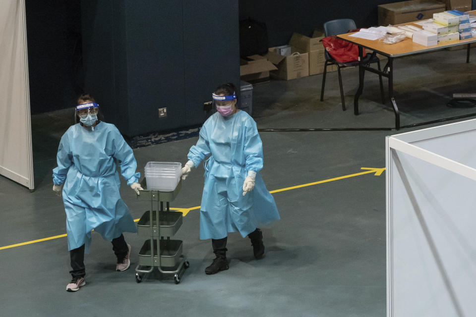 Medical workers push a collecting cart at a makeshift testing site in the Queen Elizabeth Stadium in Hong Kong Tuesday, Sept.1, 2020. Hong Kong began a voluntary mass-testing program for coronavirus Tuesday as part of a strategy to break the chain of transmission in the city's third outbreak of the disease. (Anthony Kwan /Pool Photo via AP)