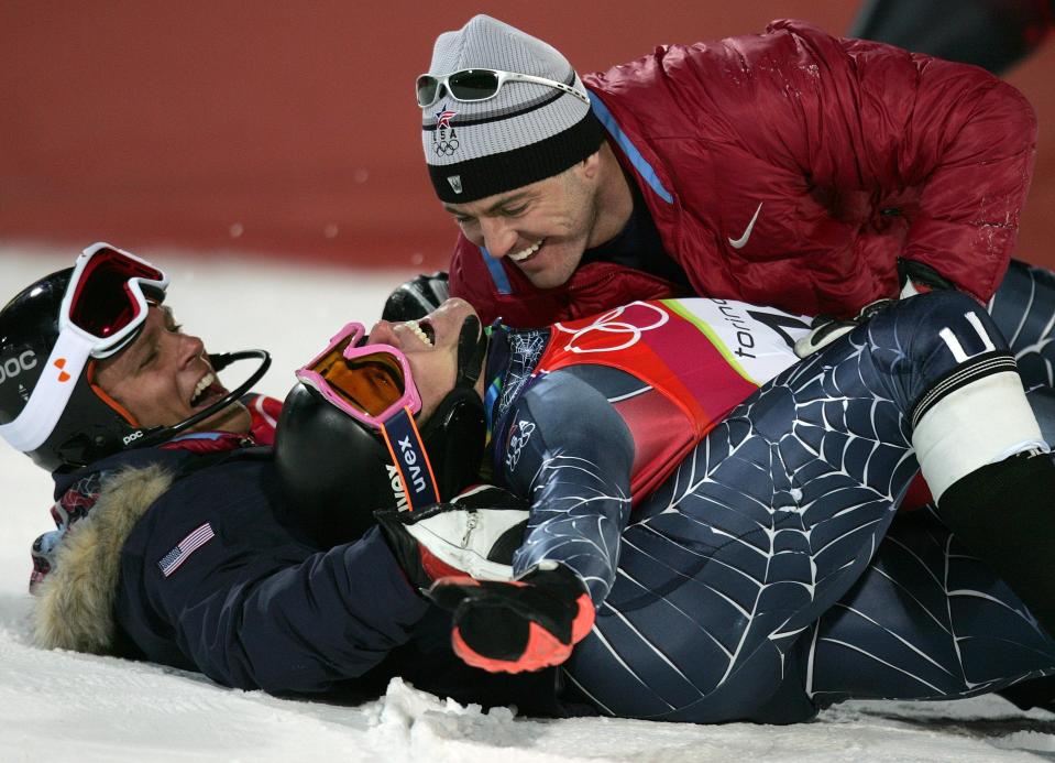 FILE - Ted Ligety of the United States, center, is embraced by teammates after winning the gold medal in the Men's Combined at the Turin 2006 Winter Olympic Games in Sestriere Colle, Italy, in this Feb. 14, 2006 file photo. Two-time Olympic champion Ted Ligety says he will retire from World Cup ski racing after the world championships. Ligety’s final race will be the giant slalom on Feb. 19 in Cortina d’Ampezzo, Italy. (AP Photo/Kevin Frayer, File)