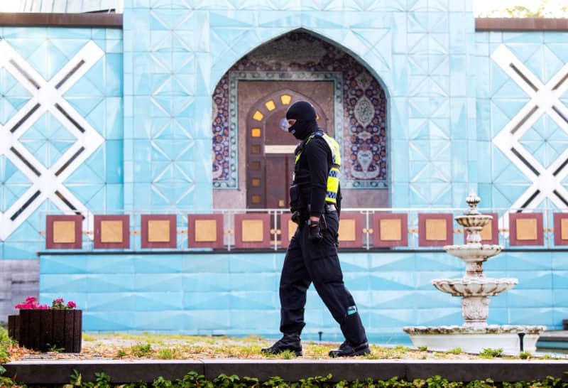 A police officer stands in front of the Islamic Center Hamburg with the Imam Ali Mosque (Blue Mosque) on the Outer Alster during a raid. Daniel Bockwoldt/dpa