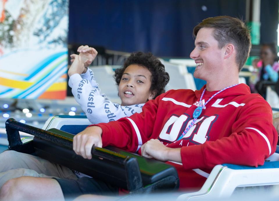 Damar Duff, left, and USI baseball player Drew Taylor ride the Himalaya during Special Kids Days at the West Side Nut Club’s Fall Festival in Evansville, Ind., Tuesday morning, Oct. 4, 2022.