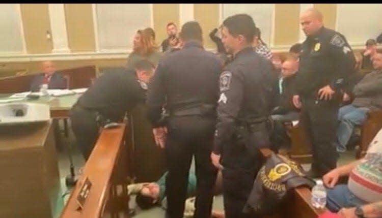 Karol Ruiz, then a Dover Board of Education member, lay on the floor of council chambers in 2019 after Mayor Dodd ordered her removed from the meeting.