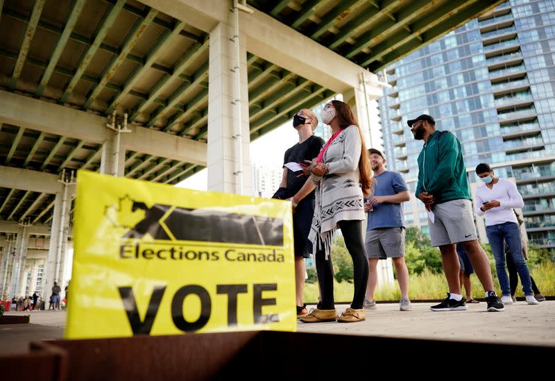 FILE PHOTO: People line up outside a polling station to vote in Toronto